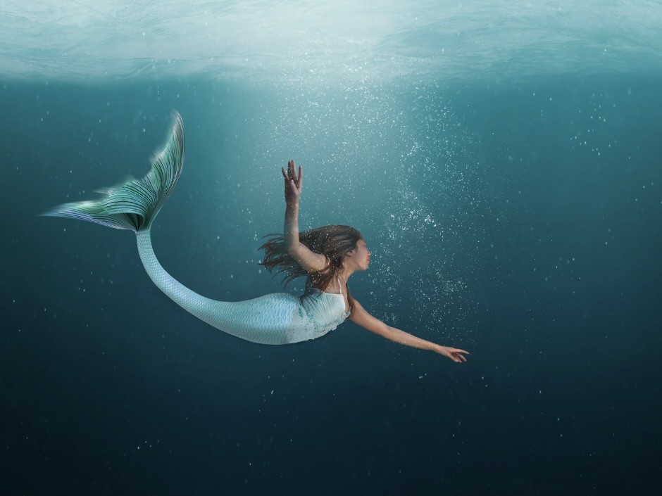 Mermaid drifting in blue ocean